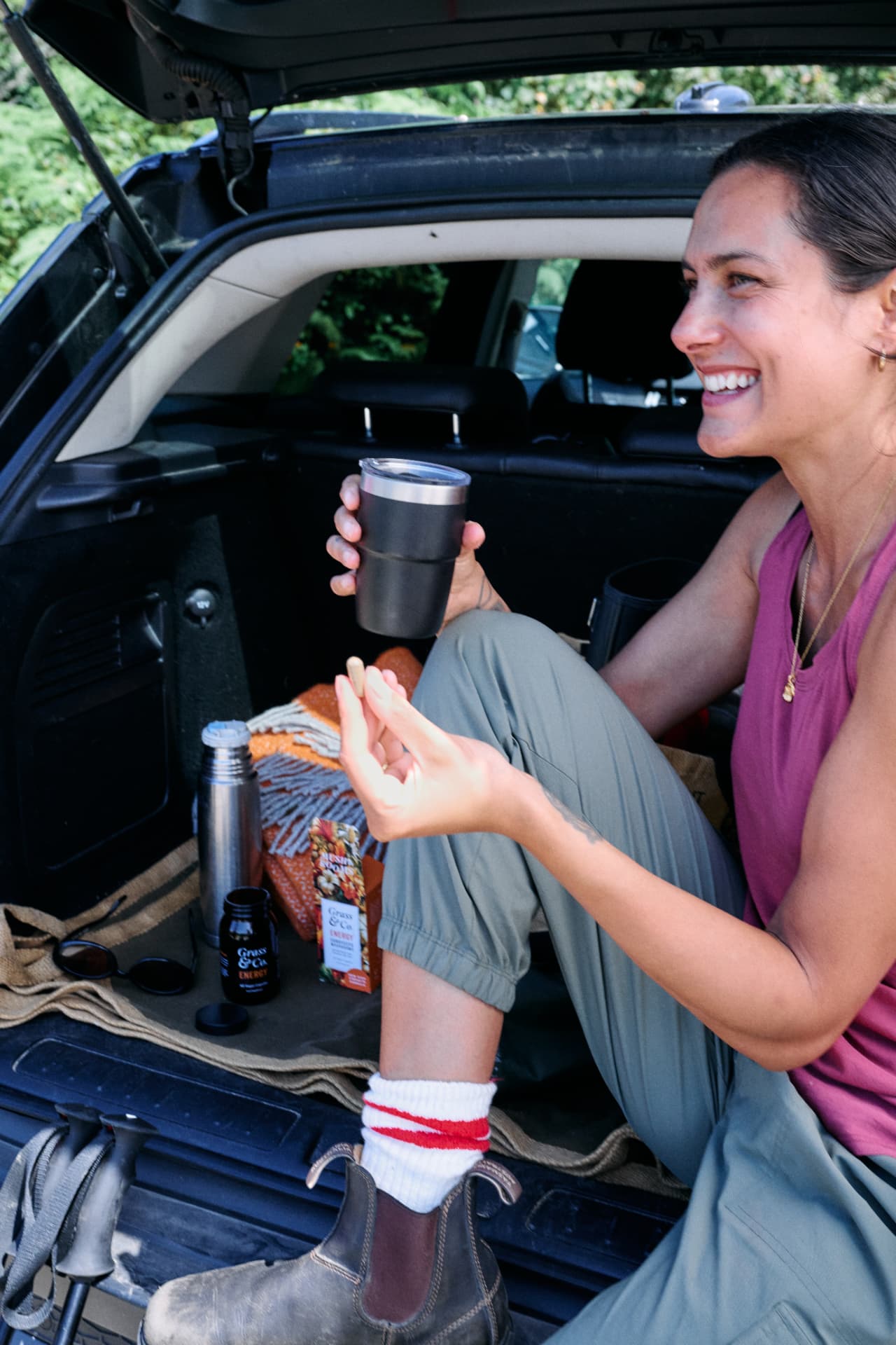 Laughing with a travel cup, ENERGY in the car boot