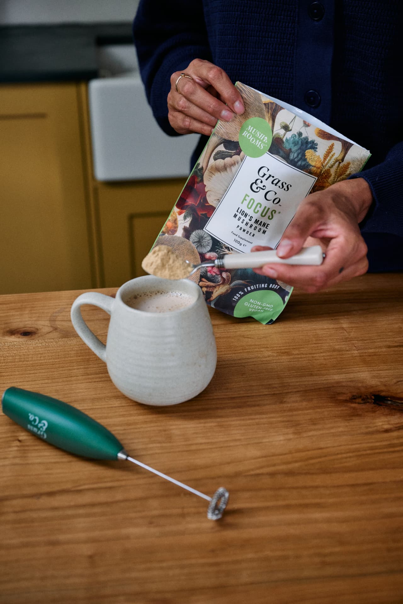 Spooning FOCUS Lion's Mane powder into a mug