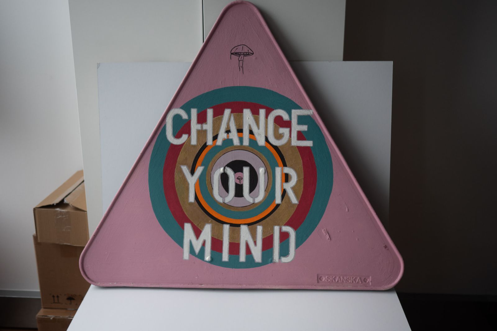 A hand-painted pink road sign reading Change Your Mind