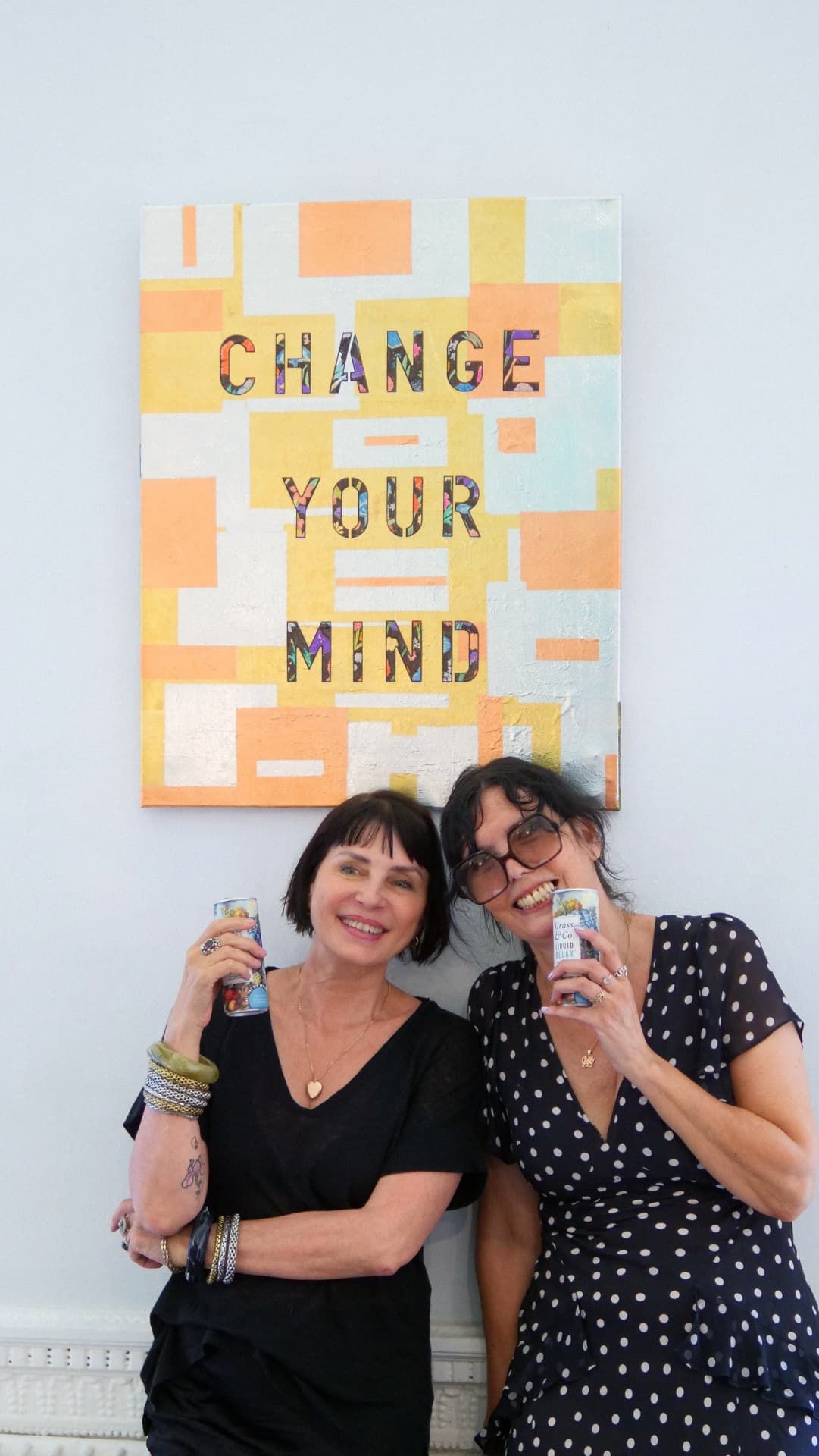 Two guests with Grass & Co. cans in front of Zoe Grace's Change Your Mind canvas