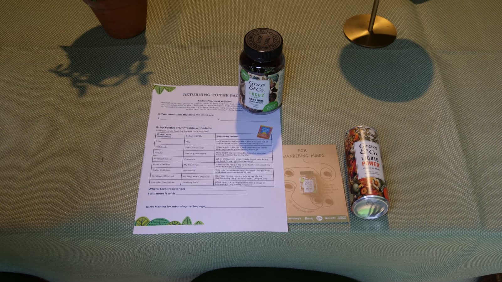 A Returning to the Page worksheet beside a jar of FOCUS gummies and a can of Liquid POWER