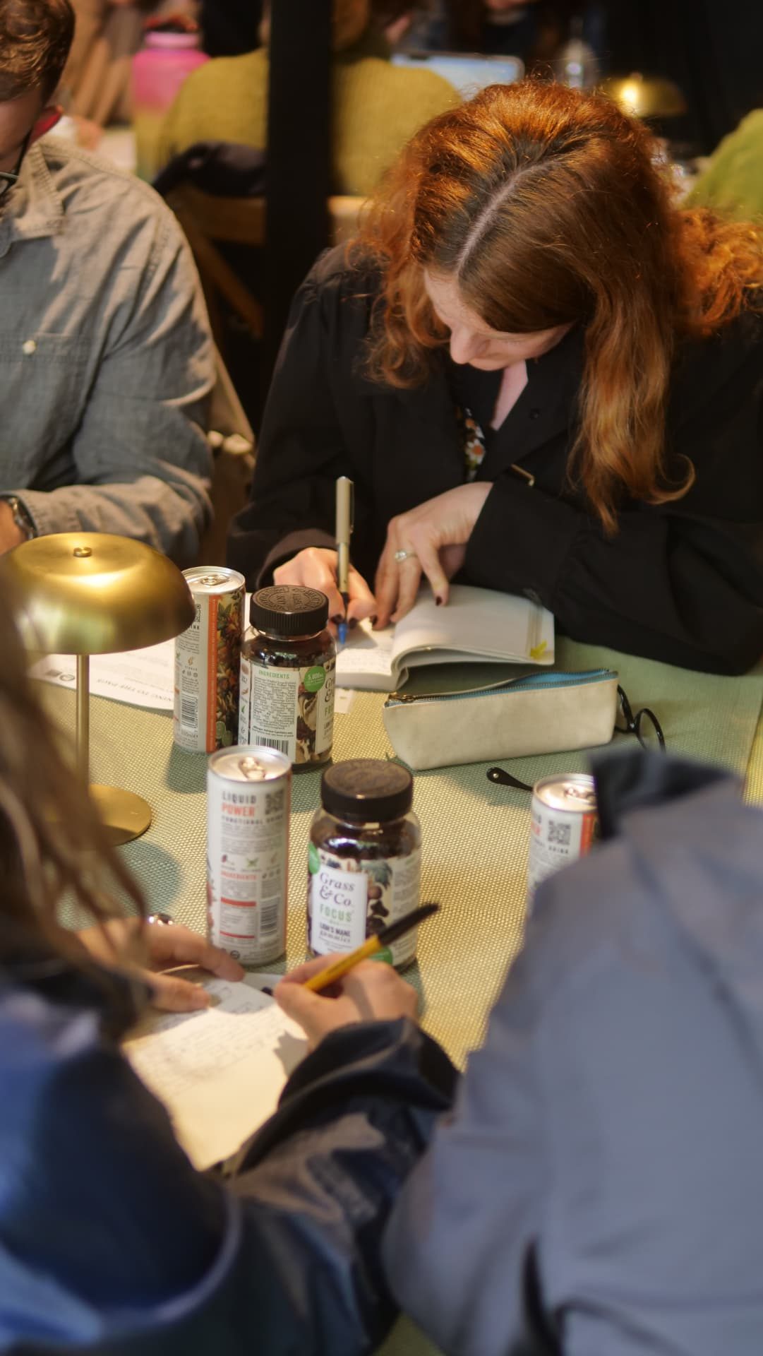 Writers making notes in the workshop with Grass & Co. FOCUS and Liquid POWER on the table